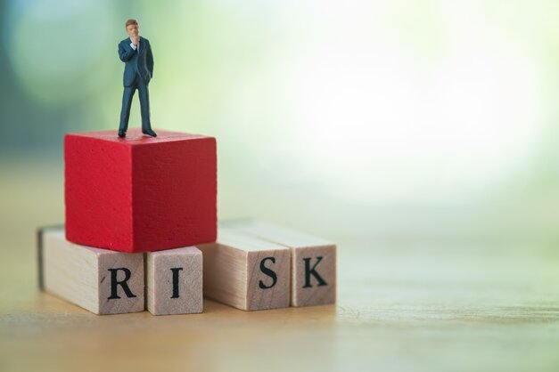 businessman standing on top of risk blocks